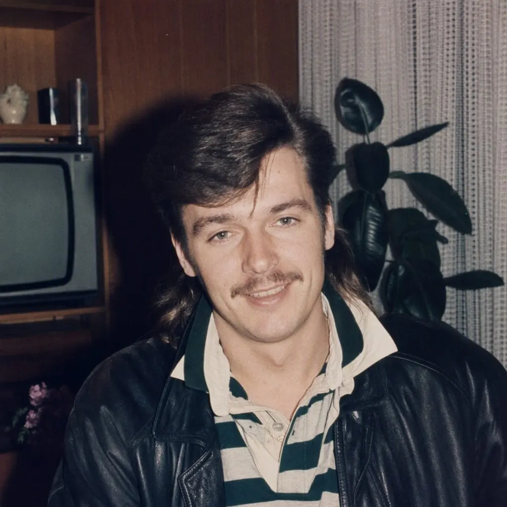 Der Look aus dem Prompt „Mann“: Vokuhila, Lederjacke über Poloshirt, Schrankwand mit Röhrenfernseher und hartes Blitzlicht
