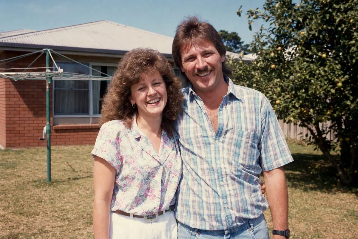 An Australian family in a suburban backyard in summer 1986, standing in front of a rotary clothes hoist in harsh midday sun