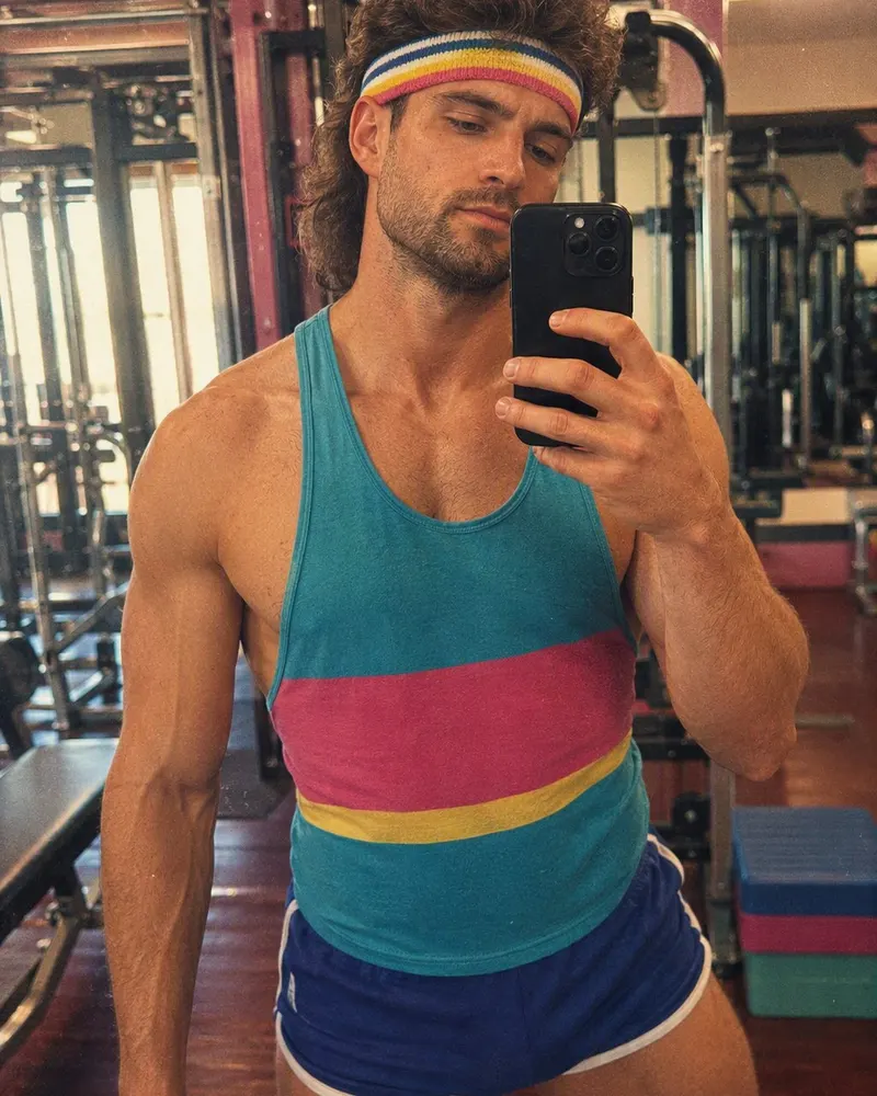 A gym selfie lands squarely in the aerobics era, headband and neon included.