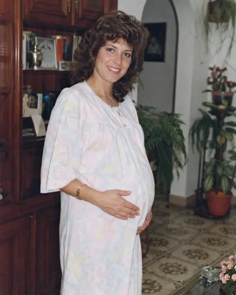 La foto de embarazo junto a la ventana se transforma en una sesión de embarazo de los 80.