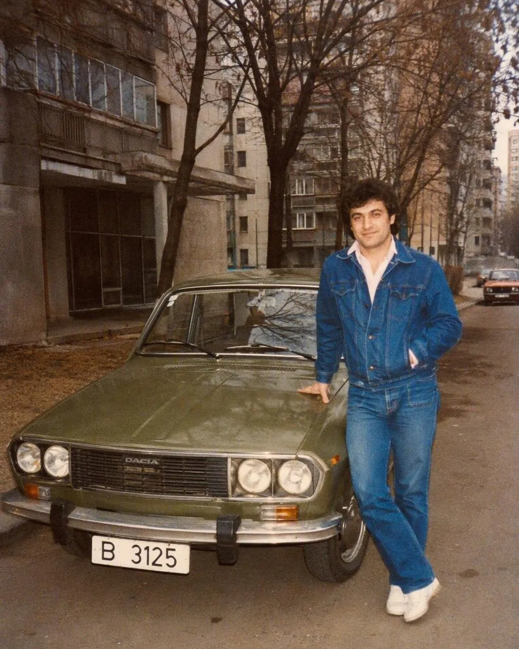 O persoană lângă o mașină de epocă, într-o seară de la mijlocul anilor 80