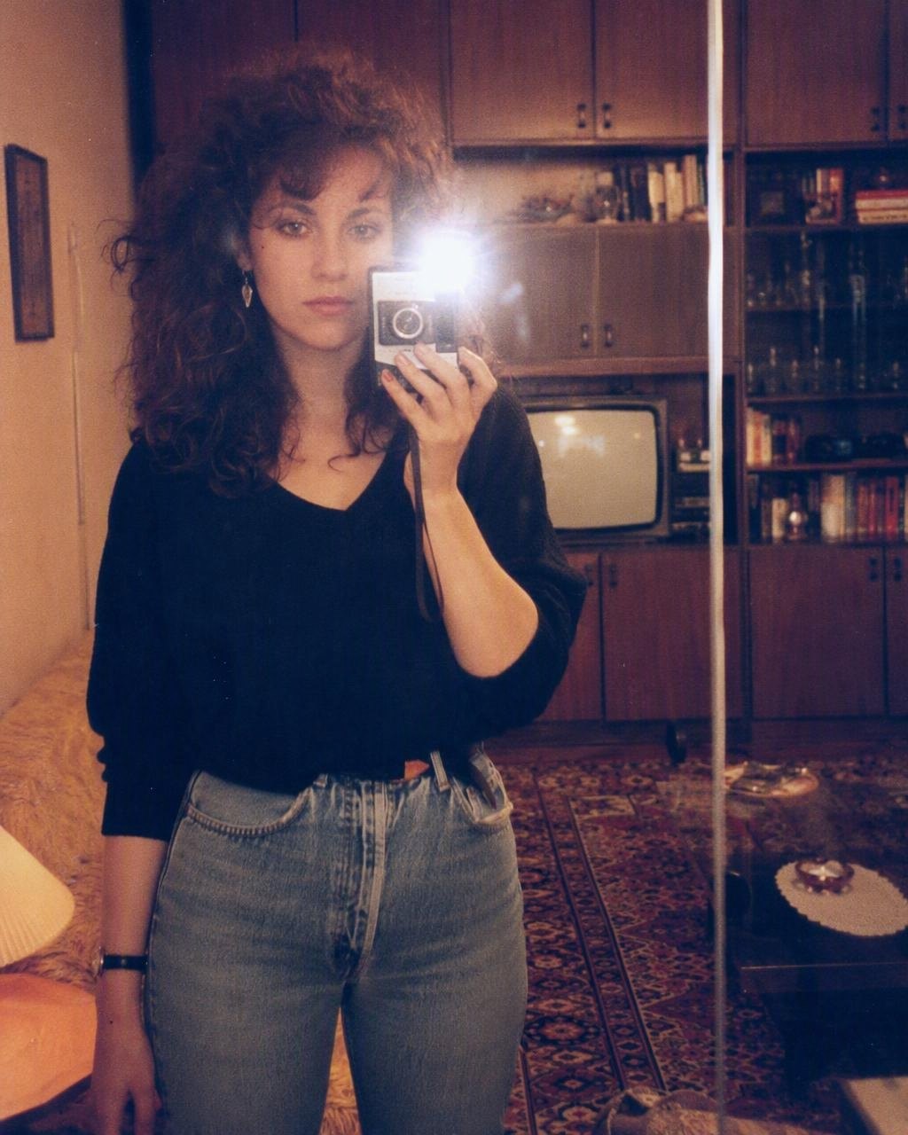 Selfi u ogledalu iz sobe postaje studijski portret iz 1986: telefon nestaje, a kosa dobija volumen.